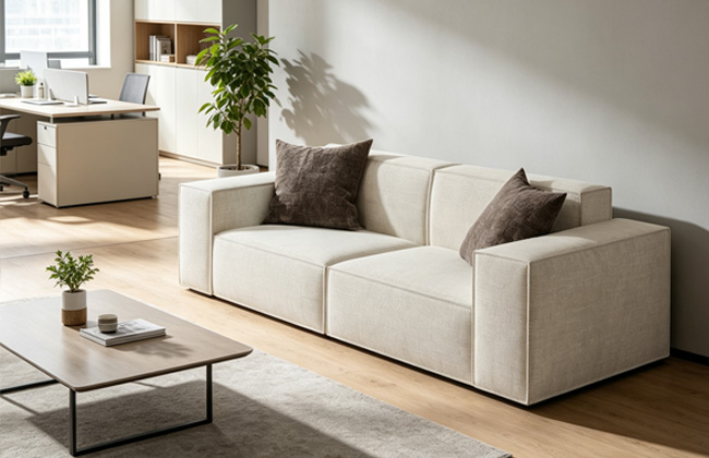 Cream office lounge sofa with dark throw pillows
