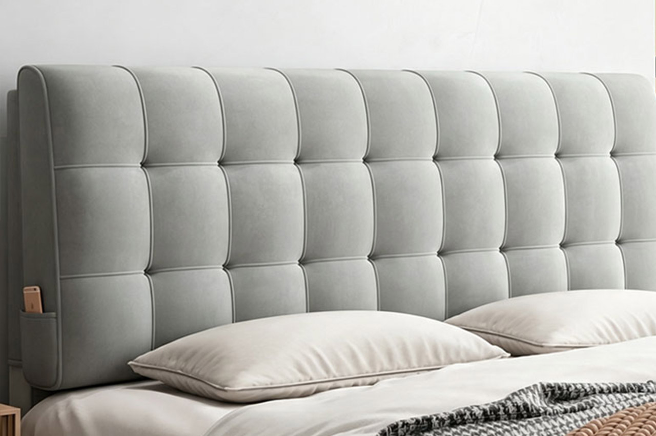Light gray tufted upholstered headboard behind a bed
