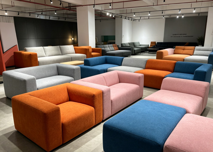 Sofa cushions in gray, pink, blue and orange arranged in a showroom