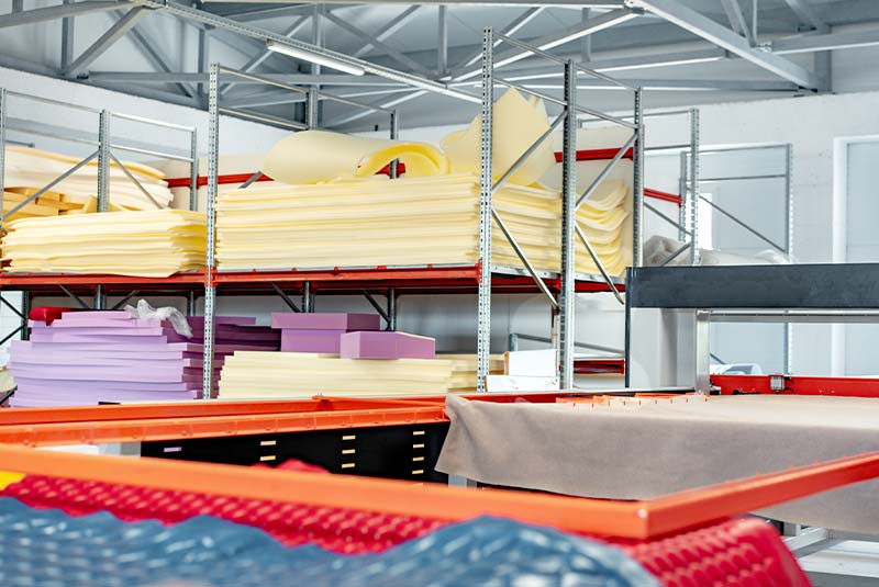 Foam sheets and cutting tables inside a furniture production workshop